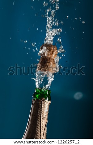 Opening a bottle of champagne with splashes