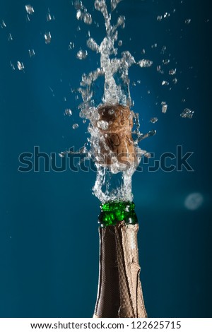 Opening a bottle of champagne with splashes