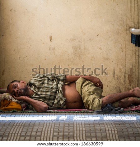 DELHI, INDIA-AUGUST 29: Hindu sleeping on the street on August 29, 2013 in Delhi, India. Hindu man sleeping on the city street