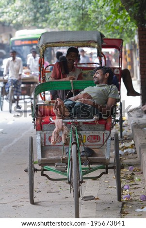 DELHI, INDIA-AUGUST 29, 2011: Unidentified Indian trishaw driver  in Delhi, India. Bicycle rickshaw on the street of Delhi.