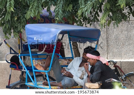 DELHI, INDIA-AUGUST 29, 2011: Unidentified Indian trishaw drivers  in Delhi, India. Bicycle rickshaw on the street of Delhi.