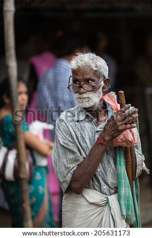 TRICHY, INDIA-FEBRUARY 14: Street of Indian city 14, 2013 in Trichy, India. Old man on the street of indian town.