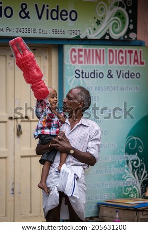 TRICHY, INDIA-FEBRUARY 14: Street of Indian city 14, 2013 in Trichy, India. Grandfather with grandson on the street of indian town