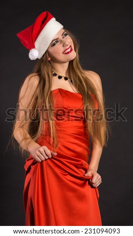 Green-eyed girl in a Christmas hat and red dress