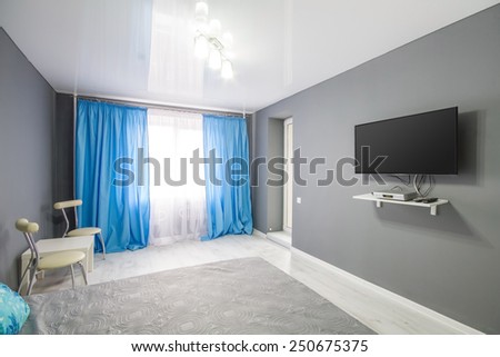 Interior of bedroom. Modern minimalist style bedroom interior in grey tones with large TV