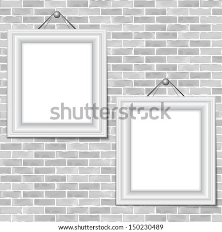 Two frames hanging on a brick wall