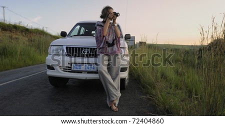 DRAKENSBERG GARDENS ROAD, SOUTH AFRICA - FEB 15: A tourist stops to catch a sunset on a country road in Underberg, South Africa on February 15, 2011.The Drakensberg is a popular tourist destination.