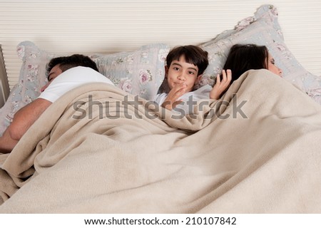 Family with mobile phone in the bed