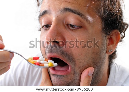 Man eating pills with a spoon . Self Medication .