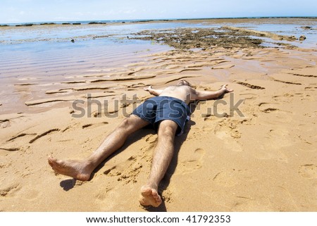 Man sunbathing in the tropical beach .