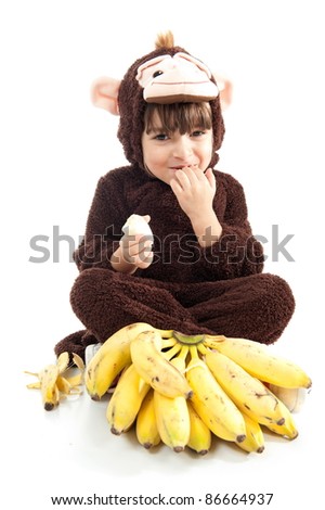 Child with monkey costume eating banana