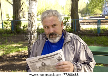 The man reads the newspaper in park