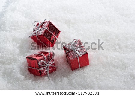 Abstract red gift boxes with white frost in snow.