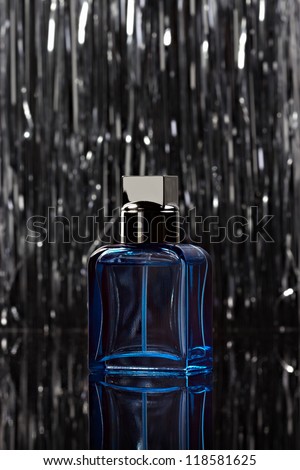 Abstract bottle of perfume over abstract background. Low key.