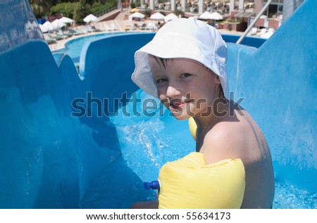 The boy is going to roll down from a waterslide