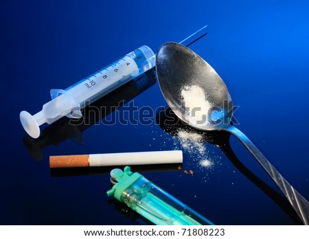 Medical Syringe, Spoon with a powder, Cigarette and lighter on dark blue background.Bad habits. An addictions.