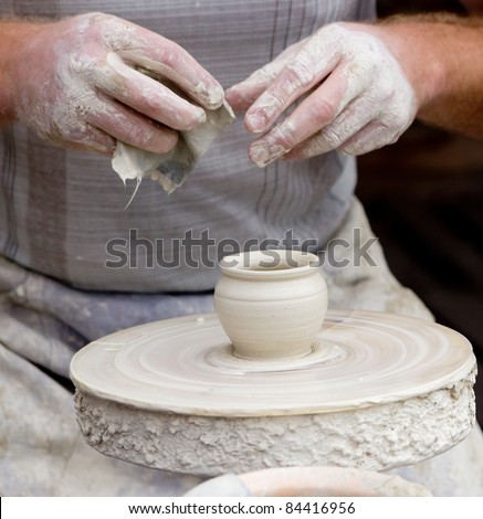 Artisan making a small potter from white clay.