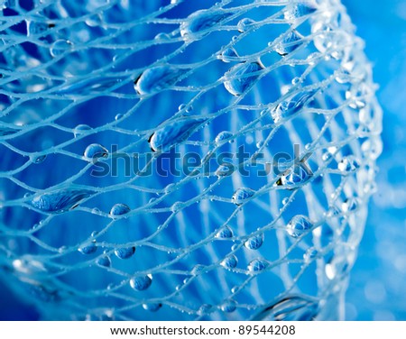 Abstract macro photo of massage blue bath sponge with water drops.