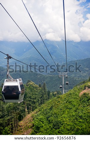 Ascension to the top of the mountain in a cable car. Clouds cover the mountains.