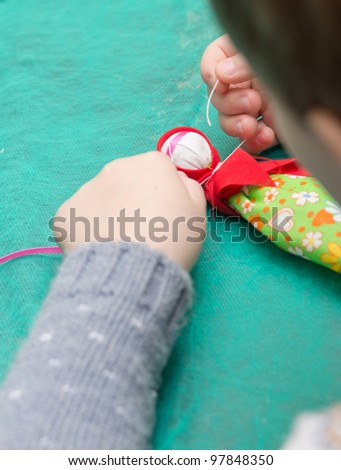 The child makes a traditional toy from different rags