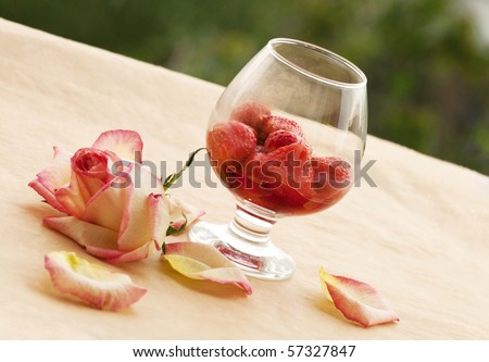 Flaming  Strawberry and ailing rose in growing misted  glass in coffee shop