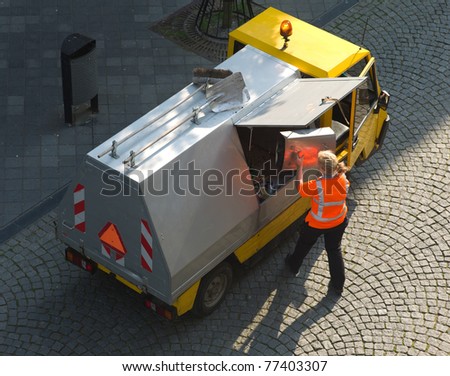 Small garbage truck with female worker