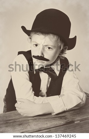 Young boy dressed as a old West bartender with a scowl