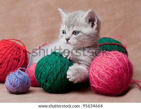 Lovely kitten with balls of threads