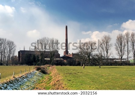 Abandoned paper factory in winter landscape