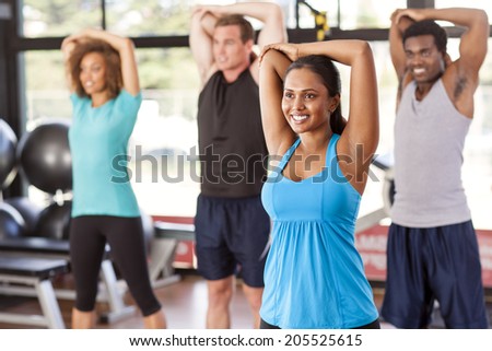 Multi-ethnic group stretching in a gym before their exercise class