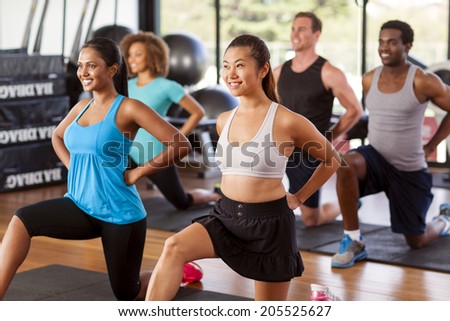 Multi-ethnic group stretching in a gym before their exercise class