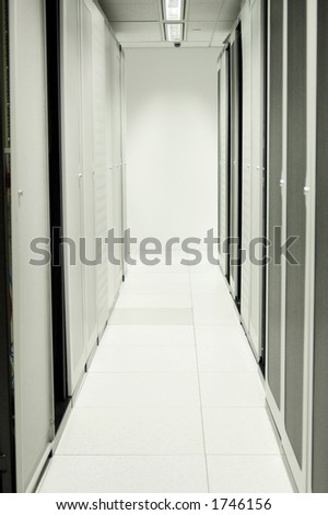 An aisle of racks in a modern datacenter.  Power distribution boards are mounted on the wall at the end.