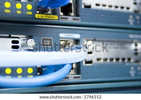 The face of a communications router with data and console cables attached.
