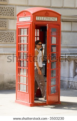 Girl inside a traditional English red telephone box
