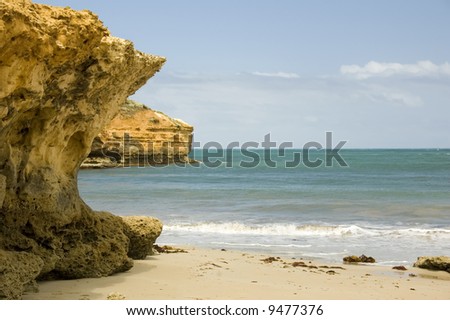 A rocky outcrop gives way to a pleasant sandy beach.