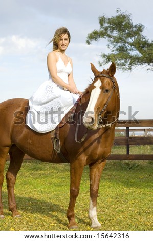 A young woman in a white dress sitting side-saddle on a horse