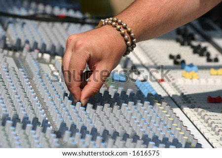 Sound engineer at mixing desk, daylight concert shot
