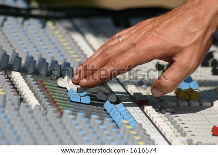 Sound engineer at mixing desk, daylight concert shot