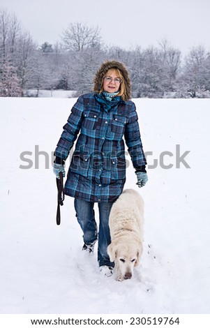 woman walking with her dog in the snow