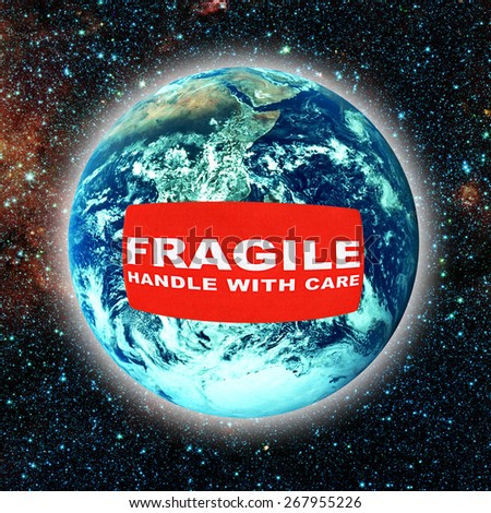 earth planet with fragile label wrapped around it (earth image provided by NASA)