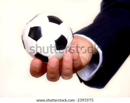 businessman holding a small soccer ball replica as concept for business and sport