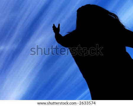 silhouette of a woman holding hand up as to reach for the light streams in the blue sky