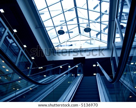 detail of an escalator and glass roof in a shopping mall