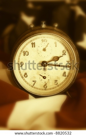 stock photo old clock standing on an american flag in sepia tonality