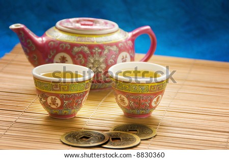 two cups of tea, tea pot and coins used for i-ching prediction