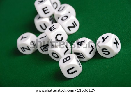 dices with letters on the faces over a green table