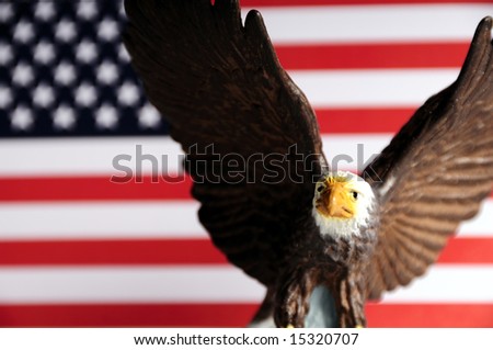 miniature toy of a bald eagle against the USA flag