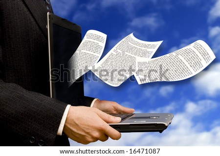 page of a book flying out of a laptop screen, held by a businessman