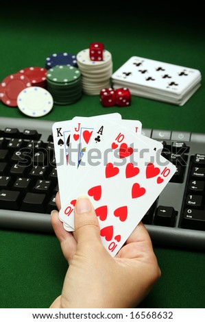 hand holding cards with computer keyboard chips and dices in background