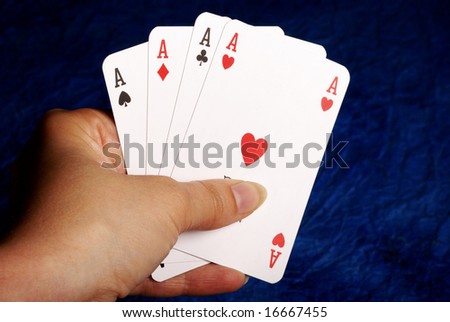 female hand holding playing cards with all four aces